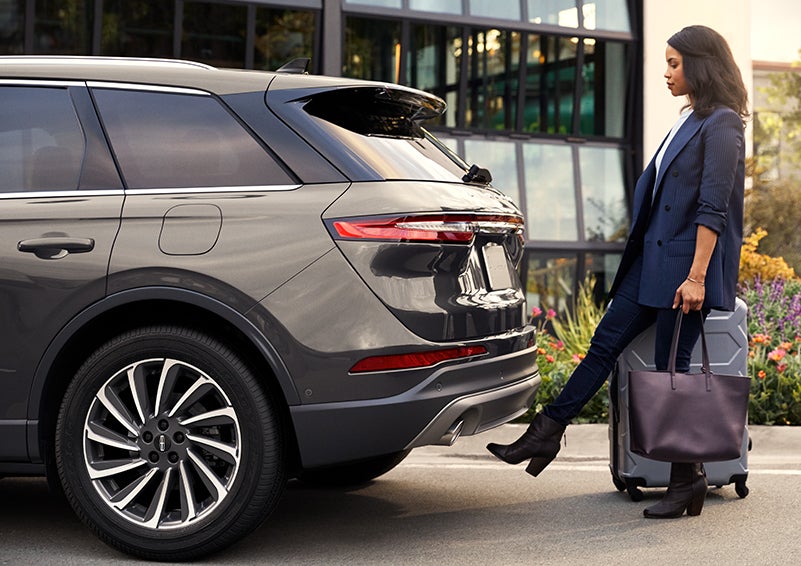 A woman with her hands full uses her foot to activate the hands-free liftgate. | Rydell Lincoln in Independence IA
