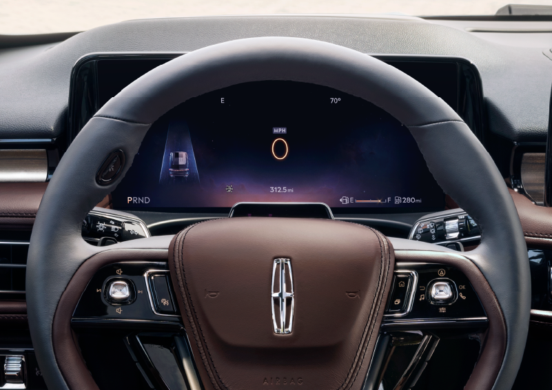 The steering wheel of 2025 Lincoln Aviator® SUV is shown with black and brown accents. | Rydell Lincoln in Independence IA