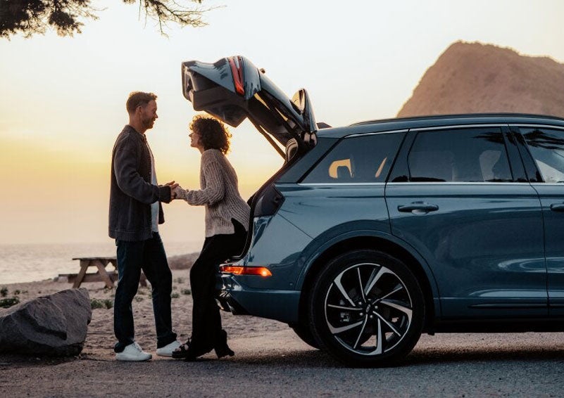 A couple share a moment together outside a 2025 Lincoln Corsair® SUV near the open liftgate. | Rydell Lincoln in Independence IA