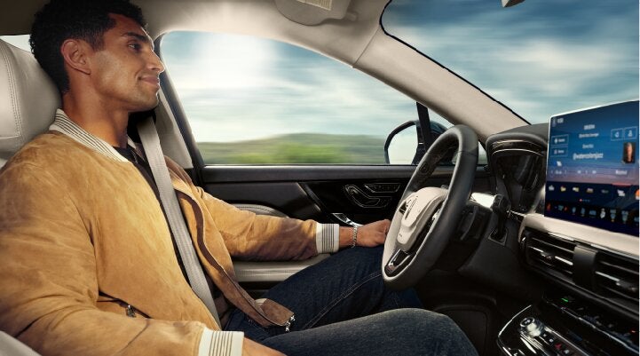 A person is shown using Lincoln BlueCruise hands-free highway driving technology on a divided highway called a Hands-Free Blue Zone. | Rydell Lincoln in Independence IA