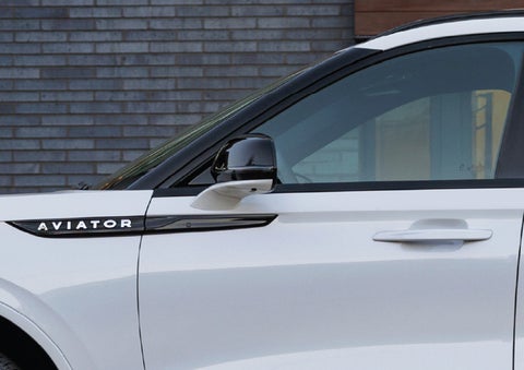 The driver’s side door and fender badging of a white 2026 Lincoln Aviator® SUV are showcased. | Rydell Lincoln in Independence IA