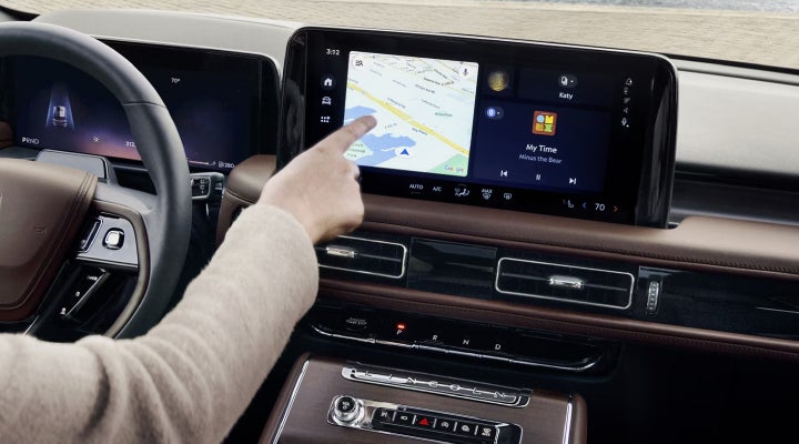 A person is tapping the center display touchscreen of a 2026 Lincoln Aviator® SUV. | Rydell Lincoln in Independence IA