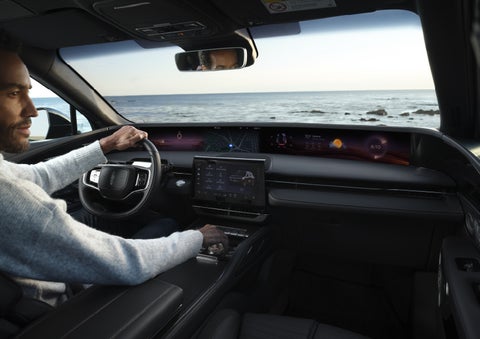 A driver of a parked 2026 Lincoln Nautilus® SUV takes a relaxing moment at a seaside overlook while inside his Nautilus. | Rydell Lincoln in Independence IA