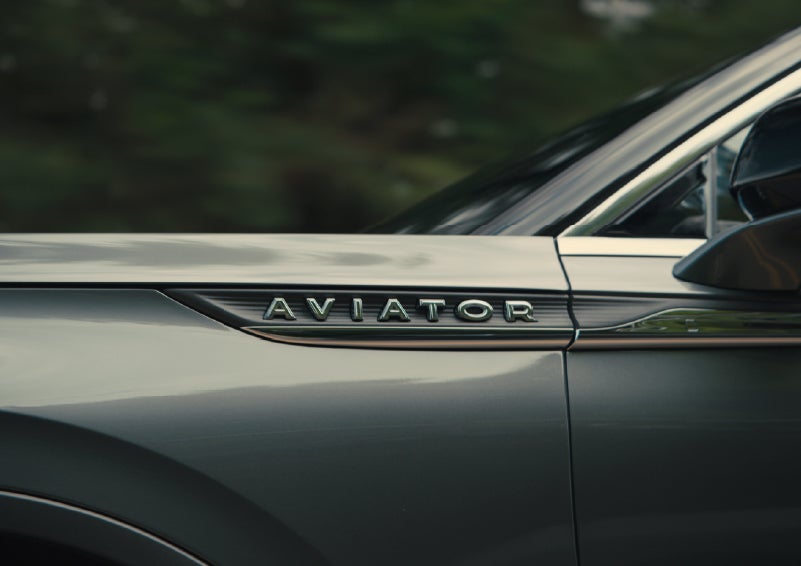 The driver’s side door and fender badging of a gray 2027 Lincoln Aviator® SUV are showcased. | Rydell Lincoln in Independence IA