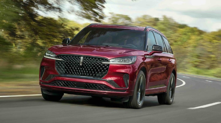 A 2027 Lincoln Aviator® SUV is being driven on a country road | Rydell Lincoln in Independence IA