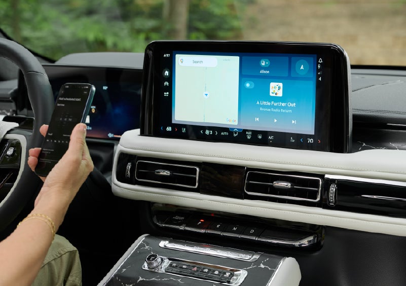 A person pairs thier phone with the center touchscreen of a 2027 Lincoln Aviator® Black Label™ SUV | Rydell Lincoln in Independence IA